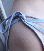 Close-up of tie straps and linen texture on a sleeveless maxi dress